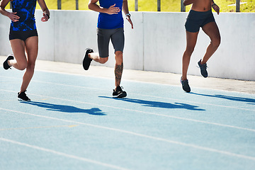 Image showing People, legs and running on stadium track for athletics, fitness or exercise in training outdoors. Leg of athlete group in sports run competition, exercising or workout for healthy cardio wellness