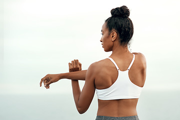 Image showing Woman, arm stretching and outdoor for yoga, workout and training with mockup. Wellness, nature and ocean with female person back doing exercise for health with pilates and relax by sea with stretch