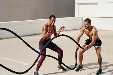 Image showing Woman, personal trainer and battle rope for workout, exercise or training in fitness outdoors. Fit, active or serious coaching with man person exercising with ropes for sports endurance or motivation