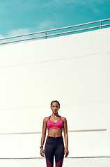 Image showing Sports, workout and portrait of serious woman with mockup, blue sky and vertical wall background at outdoor gym. Fitness, exercise and athlete with focus, sweat and healthy mindset for summer goals.