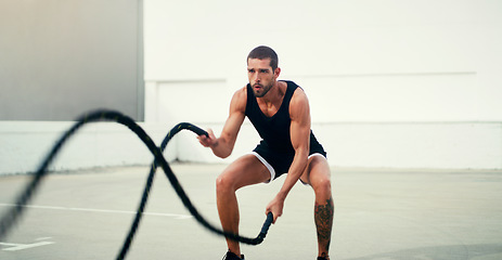 Image showing Man, fitness and battle rope exercise for physical training, workout or wellness in the outdoors. Fit, active and serious male person exercising with ropes for intense endurance, stamina or cardio