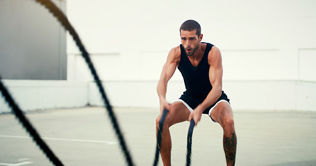 Image showing Man, fitness and battle rope workout for physical training, exercise or wellness in the outdoors. Fit, active and serious male person exercising with ropes for intense endurance, stamina or cardio