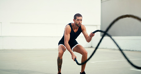 Image showing Man, fitness and battle rope training for physical exercise, workout or wellness in the outdoors. Fit, active and serious male person exercising with ropes for intense endurance, stamina or cardio