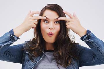 Image showing Portrait, funny face and eyes with a woman in studio on a gray background looking silly or goofy. Comedy, comic and crazy with a playful young female person joking indoor for fun or carefree humor