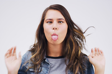 Image showing Portrait, funny face and tongue with a woman in studio on a white background looking silly or goofy. Comedy, comic or crazy and a playful young female person joking indoor for humor with an emoji