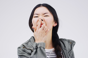 Image showing Portrait, funny face and nose with an asian woman in studio on gray background looking silly or goofy. Comedy, comic and crazy with a happy young female person joking indoor for playful fun or humor