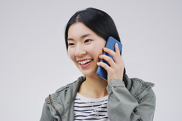 Image showing Smile, phone call and Asian woman talking in studio isolated on a white background with mockup. Funny, cellphone and female person speaking, discussion or communication, conversation and networking.