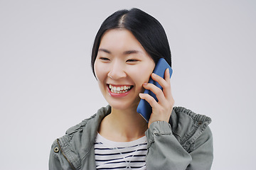 Image showing Happy, phone call and Asian woman talking in studio isolated on a white background. Funny, cellphone and female person speaking, discussion or communication, conversation and networking with contact.