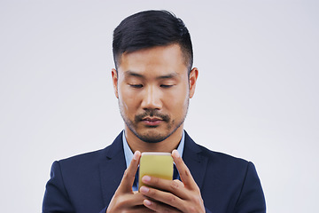 Image showing Serious, phone and Asian business man in studio isolated on a white background. Mobile, cellphone and male person typing for email, web scroll or browsing online, social media or internet app to text