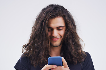 Image showing Phone, typing and face of man in studio for social media post, internet and online chat. Communication, white background and happy male person on smartphone for website, mobile app and networking