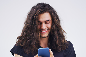 Image showing Phone, happy and man typing online in studio with smile for social media, internet and chatting. Communication mockup, white background and male person on smartphone for website, mobile app and text