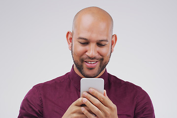 Image showing Phone, typing and man in studio with smile for social media, internet and online chat. Communication, white background and happy male person on smartphone for website, mobile app and text message