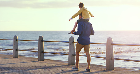 Image showing Father, child and piggyback by the beach in sunset for family bonding, playing or fun holiday or weekend in nature. Dad carrying kid on back walking by ocean coast for summer time together outdoors