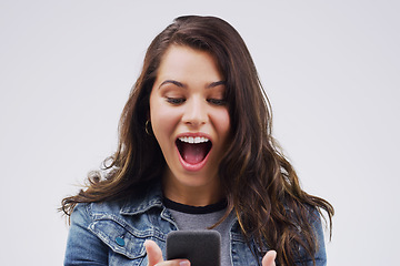 Image showing Woman, surprise and phone for winning, prize or good news against a white studio background. Shocked, surprised or excited female person reading on mobile smartphone of lottery winner in wow or bonus