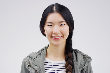 Image showing Portrait, happy or smile with an asian woman in studio on white background for japanese fashion. Face, contemporary or style with an attractive young female person looking confident in trendy clothes