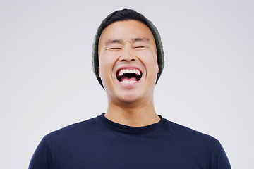 Image showing Happy, laughing and man in studio with a casual outfit excited for a comic joke or funny story. Happiness, smile and face of an Asian male person with a positive facial expression by white background