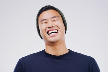 Image showing Casual, comedy and man laughing in a studio for joke, comic humor or funny story. Happiness, smile and face of an Asian male person with a positive and joyful facial expression by white background.