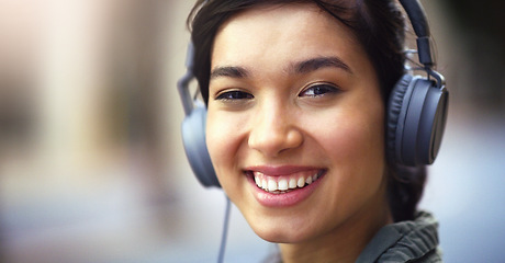 Image showing Woman in portrait, headphones in city and smile listening to music, freedom and technology outdoor. Mockup space, podcast or radio streaming with happy female person, urban and audio playlist