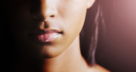 Image showing Face, closeup of woman lips and in a black background for skincare with lens flare. Cosmetics or healthcare for skin, dermatology or treatment and female person in a studio backdrop with glow