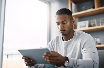 Image showing Internet, tablet and man on couch reading social media post, email or streaming video on subscription service. Scroll, search and person with serious face and checking online movie website on sofa.