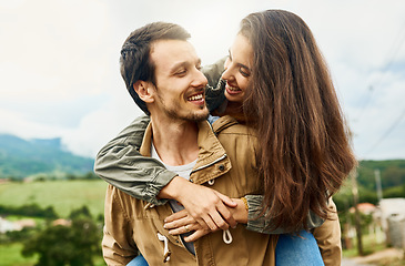 Image showing Date, love and piggyback with couple in nature for happy, smile and bonding. Happiness, relax and care with man carrying woman in countryside field for spring, anniversary vacation and travel