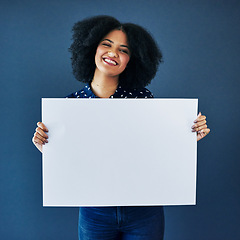 Image showing News, mockup and portrait of a woman with a poster isolated on a blue background in studio. Smile, showing and young corporate copywriter with a blank board for branding, design and information space