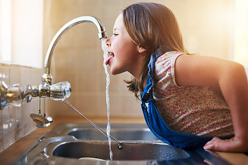 Image showing Drinking water, tap and child with tongue out in a home kitchen with a smile. House, kids and youth feeling thirsty, cheeky and curious at a sink trying to drink from faucet for hydration alone