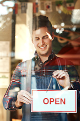 Image showing Open sign, happy and man with startup success, entrepreneur and service with restaurant, coffee shop and smile. Male person, employee and business owner with billboard, opening store and welcome