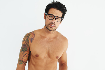 Image showing Portrait, topless and glasses with a sexy man model in studio on a white background for masculine strength. Body, tattoo and a handsome young male nerd posing shirtless for muscular confidence