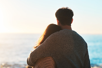 Image showing Love, beach and couple hug at sunset for relaxing, bonding and quality time on romantic date. Nature, travel and man and woman embrace for anniversary or honeymoon on holiday, weekend and vacation