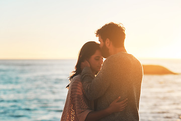 Image showing Sunset, beach and couple kiss forehead for relax, bonding and quality time on romantic date. Nature, travel and man and woman embrace for anniversary or honeymoon on holiday, weekend and vacation