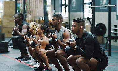 Image showing Weightlifting, fitness and people with kettle bell in gym for training, exercise and workout class. Teamwork, body builder and men and women squat with weights for challenge, wellness and strength