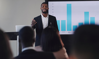 Image showing Black man, presentation and speaker with business graphs at seminar, workshop or training. Men and women crowd at a conference for learning, knowledge and financial growth or development discussion