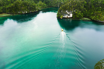 Image showing Travel, aerial and boat on island river for adventure, holiday and vacation in Indonesia. Nature, seascape and drone view of yacht in tropical water for transport, sailing and traveling on islands