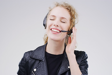 Image showing Call center, woman and listen in studio with headset, smile and communication for tech support by white background. Crm girl, telemarketing and customer service with mic, voip or happy for consulting