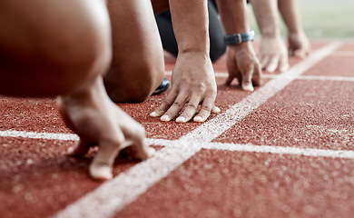 Image showing Ground, hands and people ready for a race, running competition or training at a stadium. Fitness, sports and athlete runners in a line to start a sprint, exercise or challenge in track or athletics