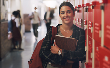 Image showing Portrait, education and notebook break with a girl by her locker in the hallway of her school. Learning, university or scholarship with a college pupil holding research books for studying knowledge