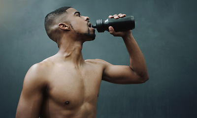 Image showing Fitness, man and drinking water on wall background after workout, exercise and training at a gym. Bottle, hydration and male relax after cardio, bodybuilding or challenge at sports center with space