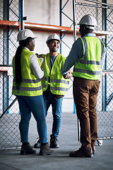 Image showing Builder, team and handshake at a construction site for a collaboration and partnership. Professional, contractor.and greeting at a warehouse for a job and project with a contract at a company.