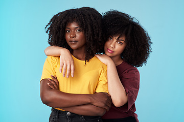 Image showing Portrait, diversity and support with friends on a blue background in studio together for freedom or empowerment. Love, trust and an attractive young black female standing arms crossed with a friend