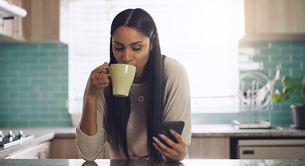 Image showing Phone, texting and woman with coffee in a kitchen relax with social media, app or reading. Smartphone, streaming and female drinking tea in her home in the morning, calm and peaceful in her apartment