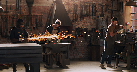 Image showing Hammer, anvil and sparks with men in a workshop for metal work manufacturing or production. Industry, welding and trade with blacksmith professionals at work in a factory, plant or industrial forge