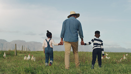 Image showing Family, holding hands and a dad walking on a farm with his children for agriculture or sustainability. Back, farming an a father with his kids in the meadow as a cow farmer in the natural countryside