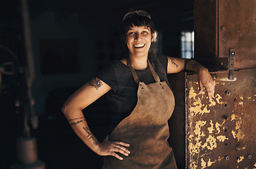 Image showing Woman blacksmith, portrait and happy in workshop for industry, trade or entrepreneurship in foundry. Small business owner, female entrepreneur or labor in factory, industrial warehouse or metalwork