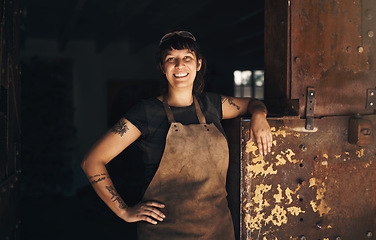 Image showing Woman blacksmith, portrait and smile in factory, industry and trade for entrepreneurship at artisan job. Small business owner, female entrepreneur and labor in industrial warehouse with manufacturing