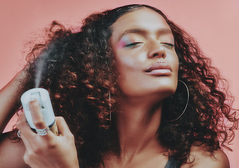 Image showing Hairspray, curly hair and beauty with woman in studio for hairstyle, self care and natural. Skincare, makeup and cosmetics with female model isolated on pink background for pride, glow and texture