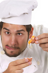 Image showing young funny chef cracking an egg