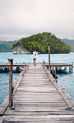 Image showing Island, travel and woman on ocean deck for holiday, summer vacation and weekend getaway in Maldives. Traveling, tropical villa and female person on luxury resort for relax, happiness and adventure