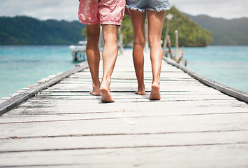 Image showing Couple legs, walking and deck on a tropical island on vacation with freedom by sea. Ocean, beach and Thailand walk of a man back and woman together with love in summer on a holiday outdoor in sun