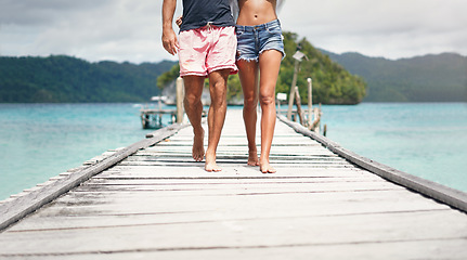 Image showing Travel couple, walking and beach deck on holiday with freedom and love in summer in Thailand. Tropical nature, sea and legs of people on a boardwalk walk in the sun on vacation break by ocean water